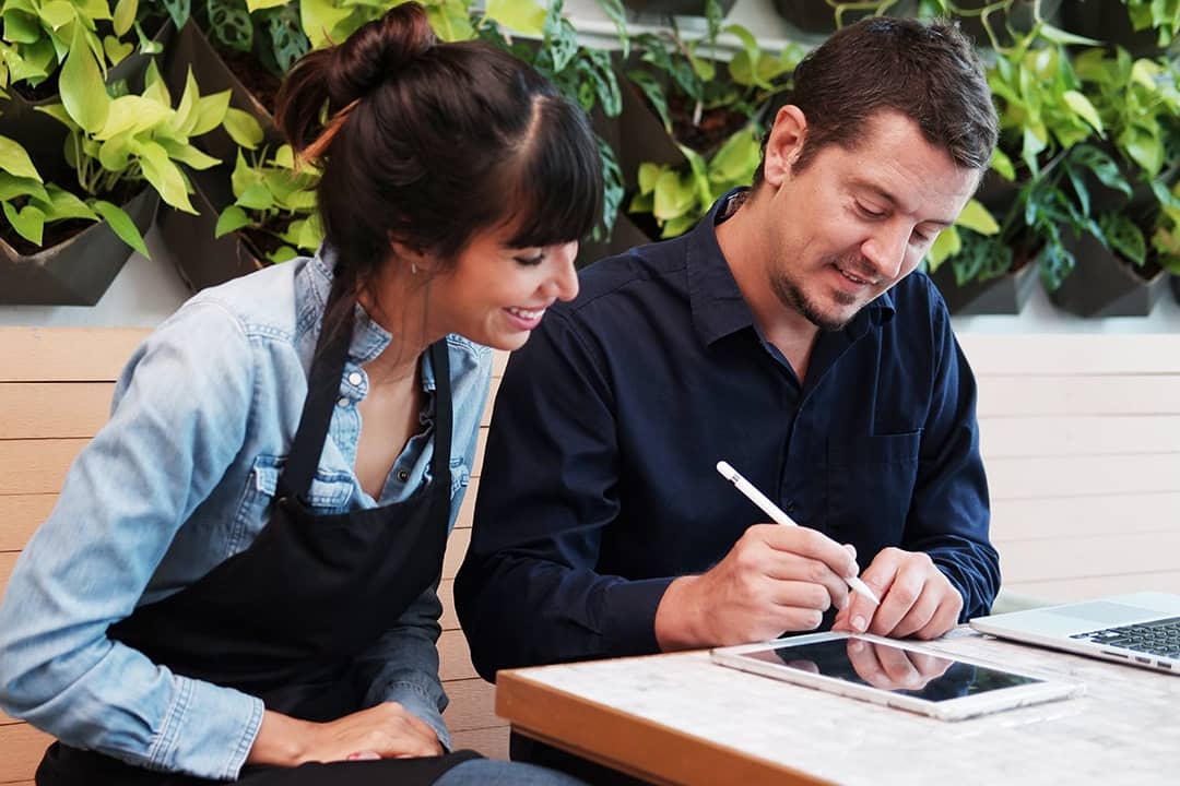 A couple who are small business owners discussing reports together in their store.